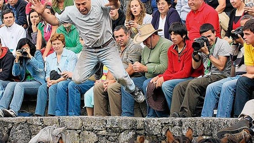 Un aloitador salta desde la grada sobre los caballos en el curro de ayer, ante la expectación del graderío.