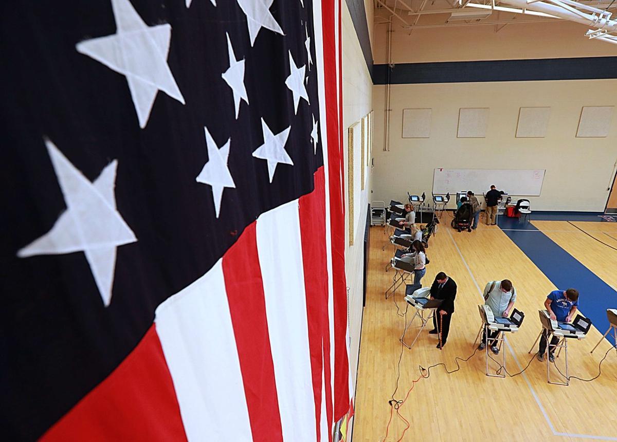 PROVO, UT - NOVEMBER 08: With a large American flag on the wall, people cast their ballot in the presidential election at Freedom Academy elementary school on November 8, 2016 in Provo, Utah. Americans across the nation are picking their choice for the next president of the United States.   George Frey/Getty Images/AFP