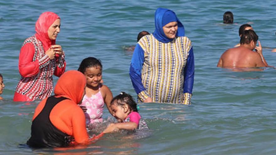 Varias mujeres se bañan con el burkini.