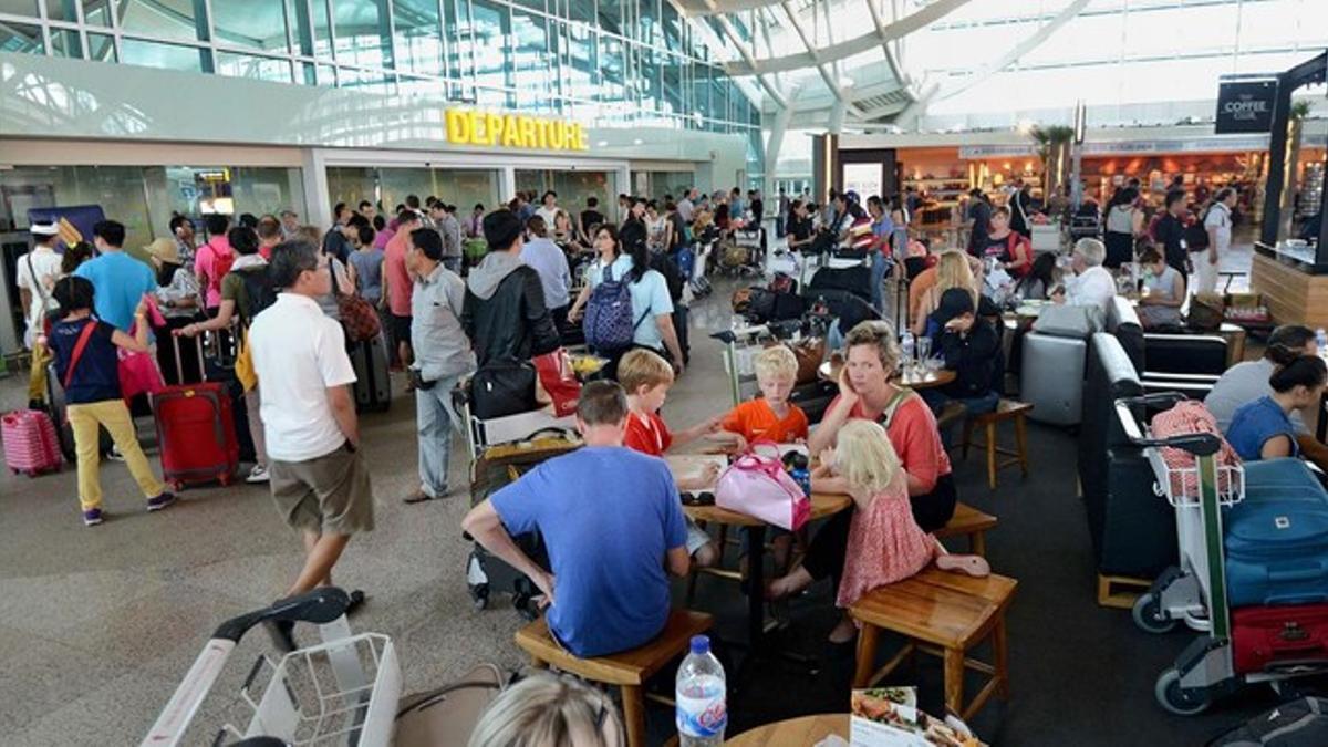 Cientos de pasajeros esperan recibir información sobre sus vuelos en el aeropuerto de Bali, en Denpasar, este viernes.