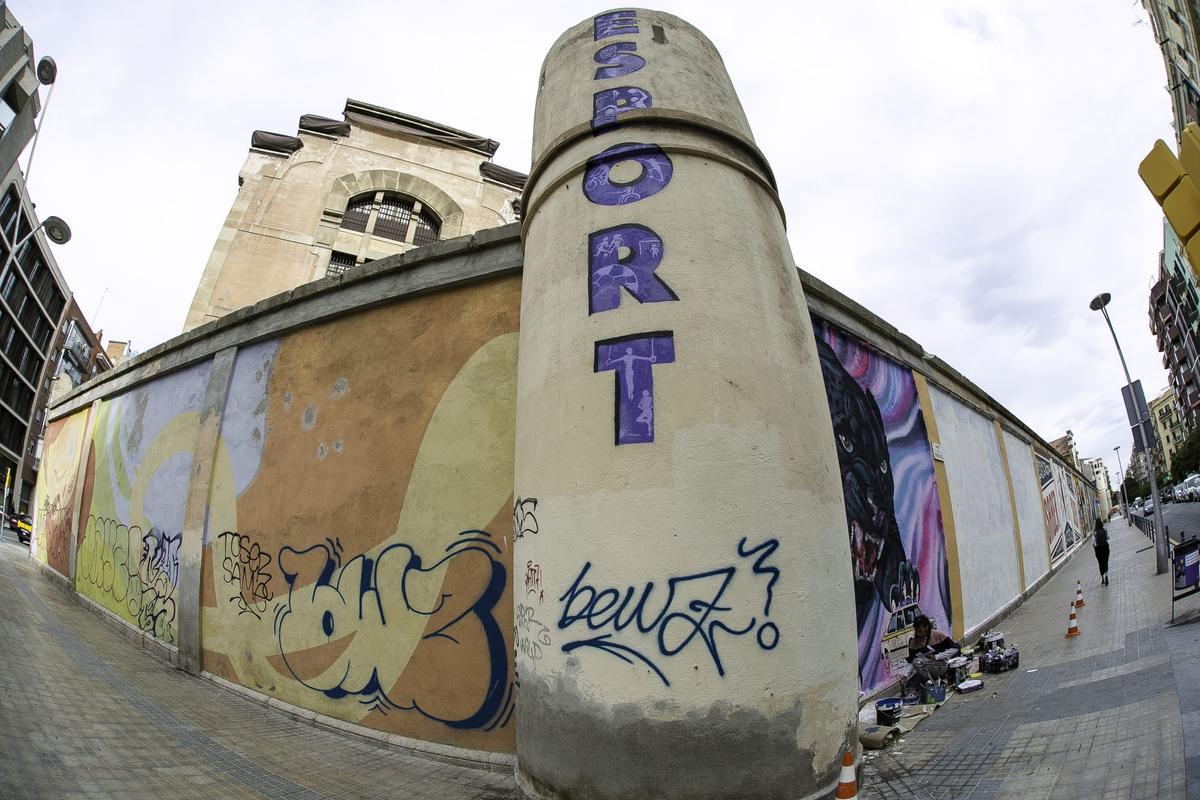 Artistas urbanos pintan los muros de la cárcel Modelo de Barcelona.