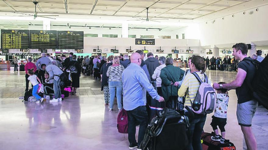 Cientos de turistas hacen cola en el aeropuerto de Lanzarote para salir de la isla tras decretarse el estado de alarma.