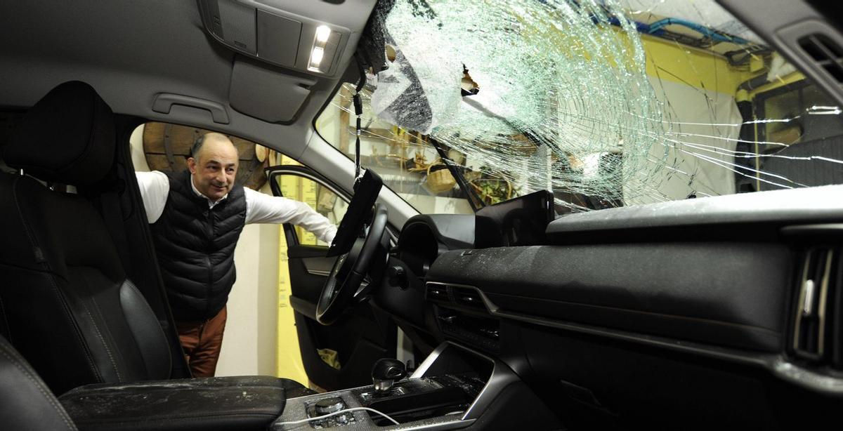 Sindo Argiz posa en su vehículo (arriba). Imagen del puente y de la piedra que arrojaron (abajo). | BERNABÉ/JAVIER LALÍN