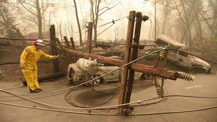 Un bombero evalúa los desperfectos ocasionados por el fuego en la localidad de Paradise, completamente arrasada.  // AFP