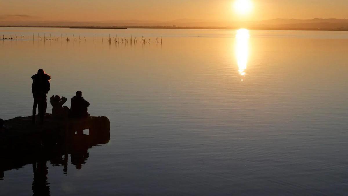 Un grupo de personas observa la puesta de sol en l' Albufera de Valencia.