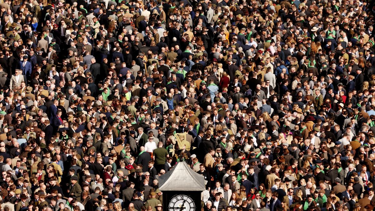 Una multitud se agolpa para presenciar las carreras de caballos en Cheltenham por el día de San Patricio.