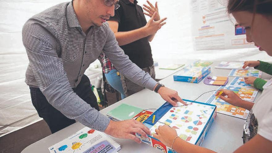 Un investigador predoctoral realiza un test de altas capacidades a una niña en una feria de la ciencia.