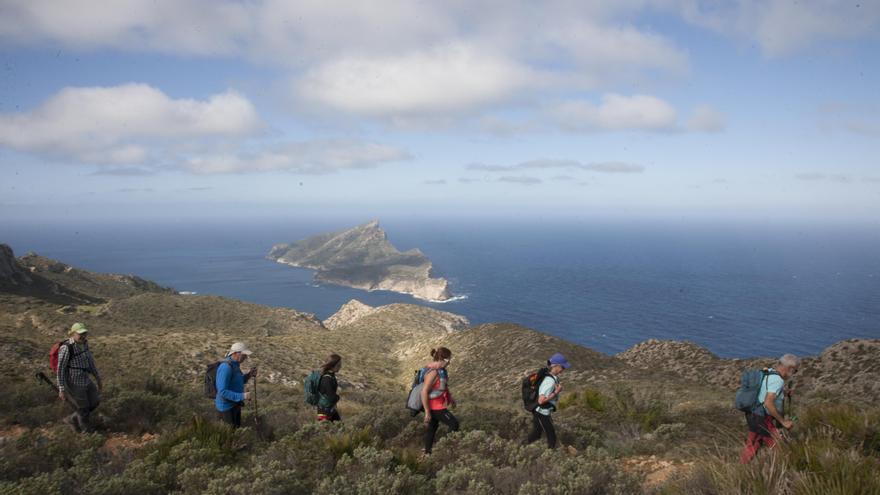 Els excursionistes amb l’illa de Sa Dragonera al fons