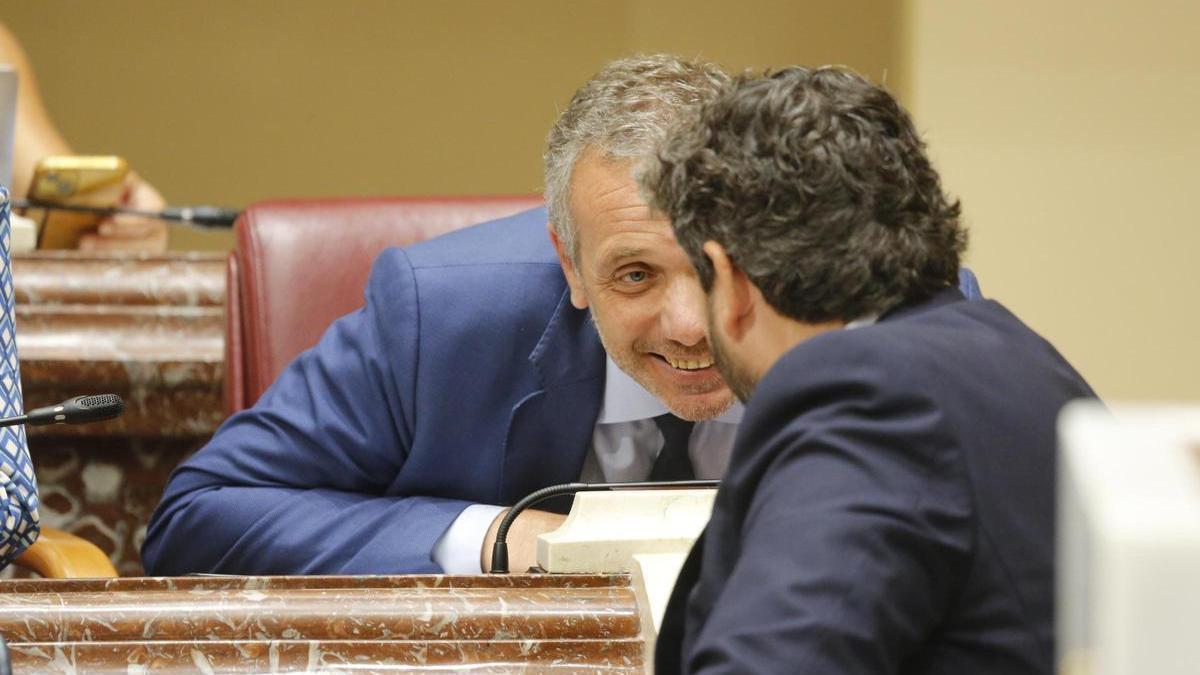 Joaquín Segado habla con Fernando López Miras durante un Pleno de la Asamblea.