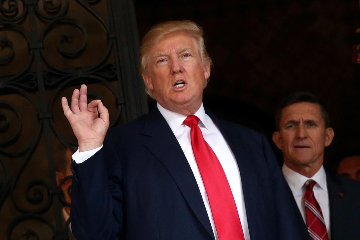 FILE PHOTO: U.S. President-elect Donald Trump talks to members of the media as retired U.S. Army Lieutenant General Michael Flynn stands next to him at Mar-a-Lago estate in Palm Beach, Florida, U.S., December 21, 2016. REUTERS/Carlos Barria/File Photo