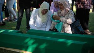 Mujeres musulmanas bosnias lloran sobre los ataúdes con los restos durante una ceremonia fúnebre por cincuenta víctimas musulmanas bosnias recién identificadas, en el Centro Memorial y Cementerio de Potocari en Srebrenica, Bosnia y Herzegovina, el 11 de julio de 2022. 