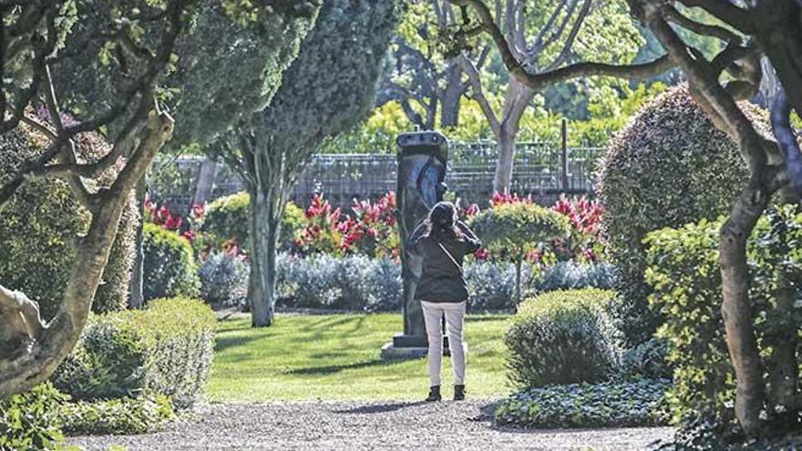 Una visitante a los jardines de Marivent fotografía una de las esculturas de Miró.