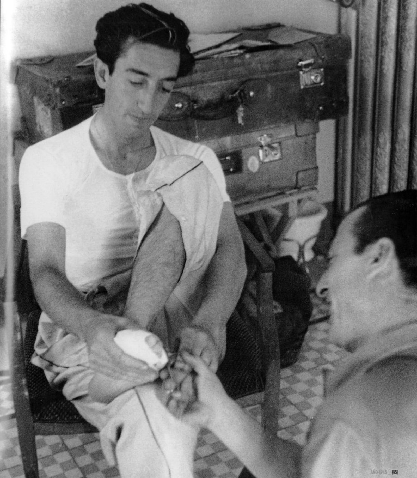 Guillermo, el mozo de espadas, venda el pie de Manolete en el hotel de Granada, mientras se viste para la corrida del Corpus de  1945.