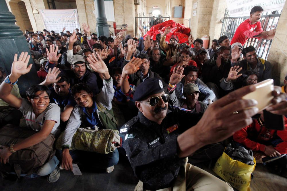 Pescadores indios que fueron apresados por cruzar las aguas territoriales con Pakistán saludan para un 'selfi' con un agente de policía tras su liberación en la estación de tren de Cantonment, Karachi, Pakistán.