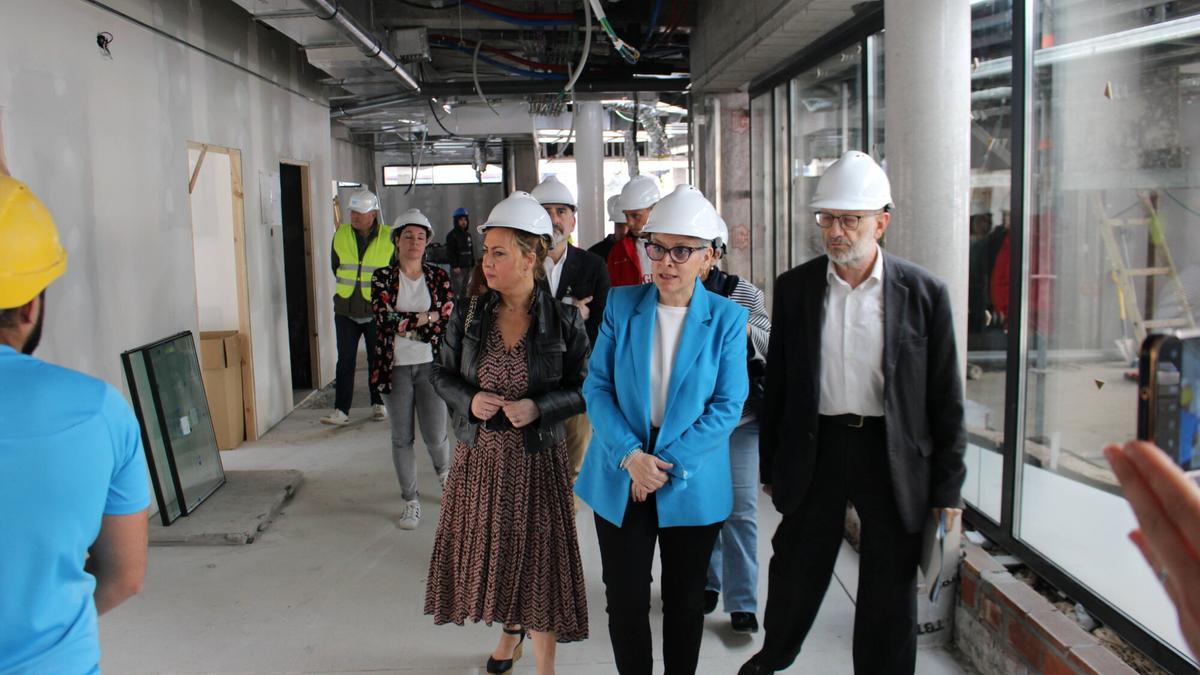 Por la izquierda, Gemma Álvarez y Concepción Saavedra, durane la vista a las obras del centro de salud de Pola de Lena.