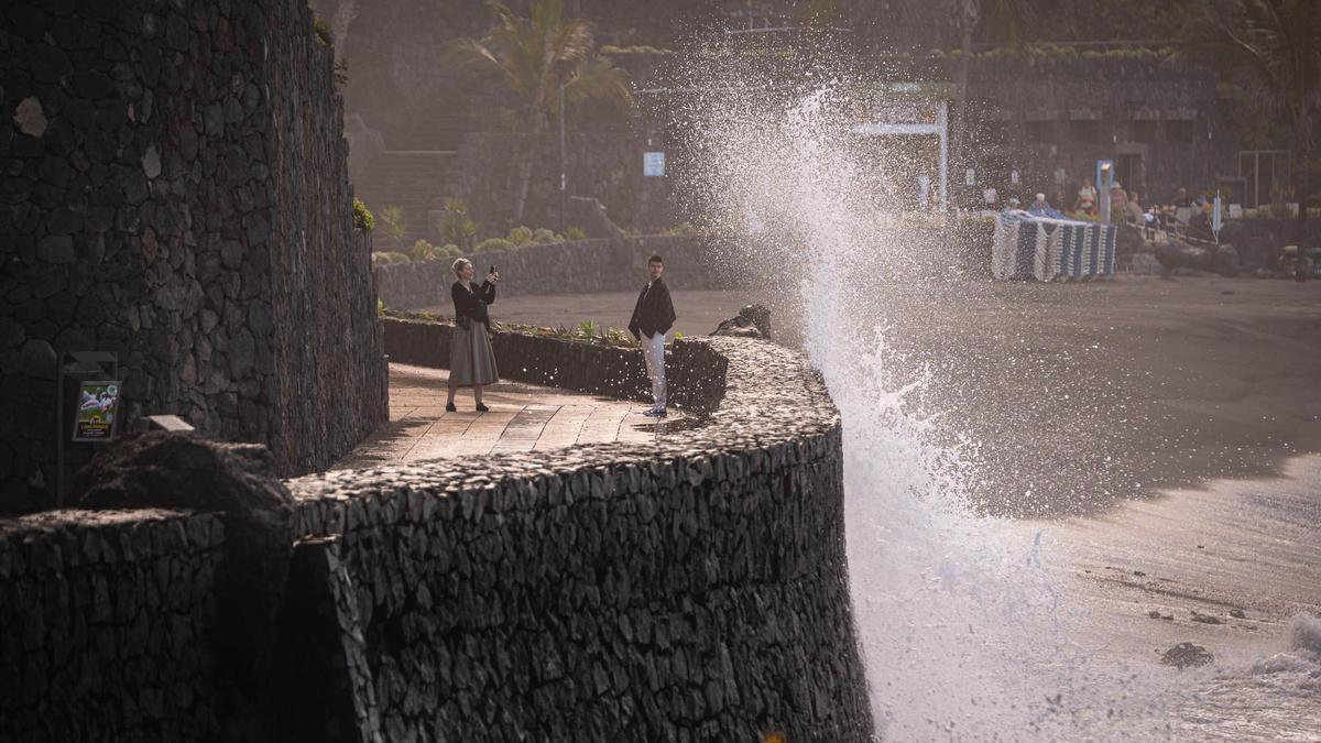 Dos personas se sacan fotos junto al mar pese a los avisos por fuerte oleaje debido a Therese.