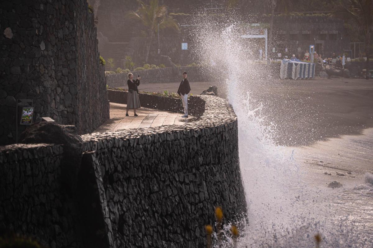 Dos personas se sacan fotos junto al mar pese a los avisos por fuerte oleaje debido a Therese.