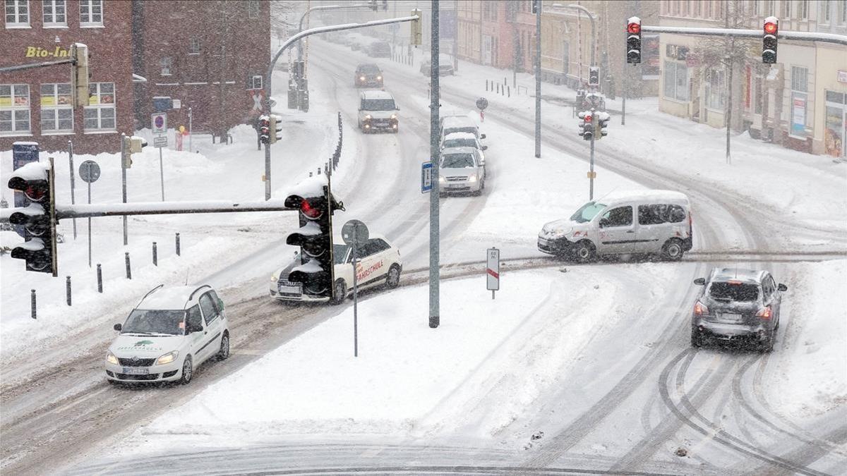 Varios coches avanzan por la carretera bajo una tormenta de nieve en Stalsund, Alemania.