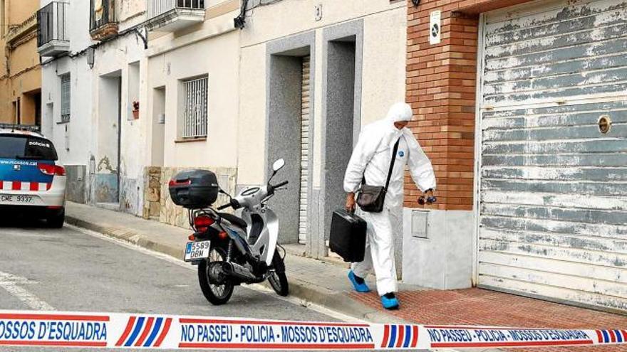 Un agent de la policia científica surt del domicili del crim, al número 3 del carrer Concepció