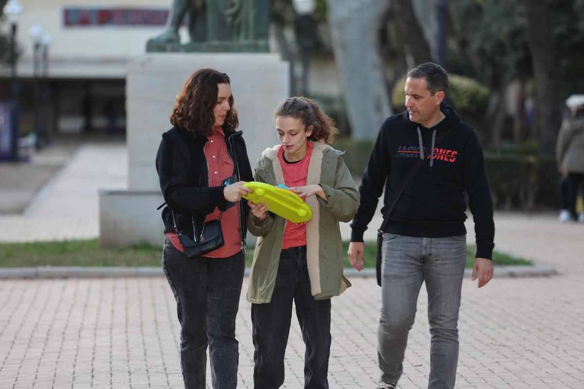 Celia, de 13 años, pasea por su barrio en Castellón con sus padres, Amanda y Jesús.
