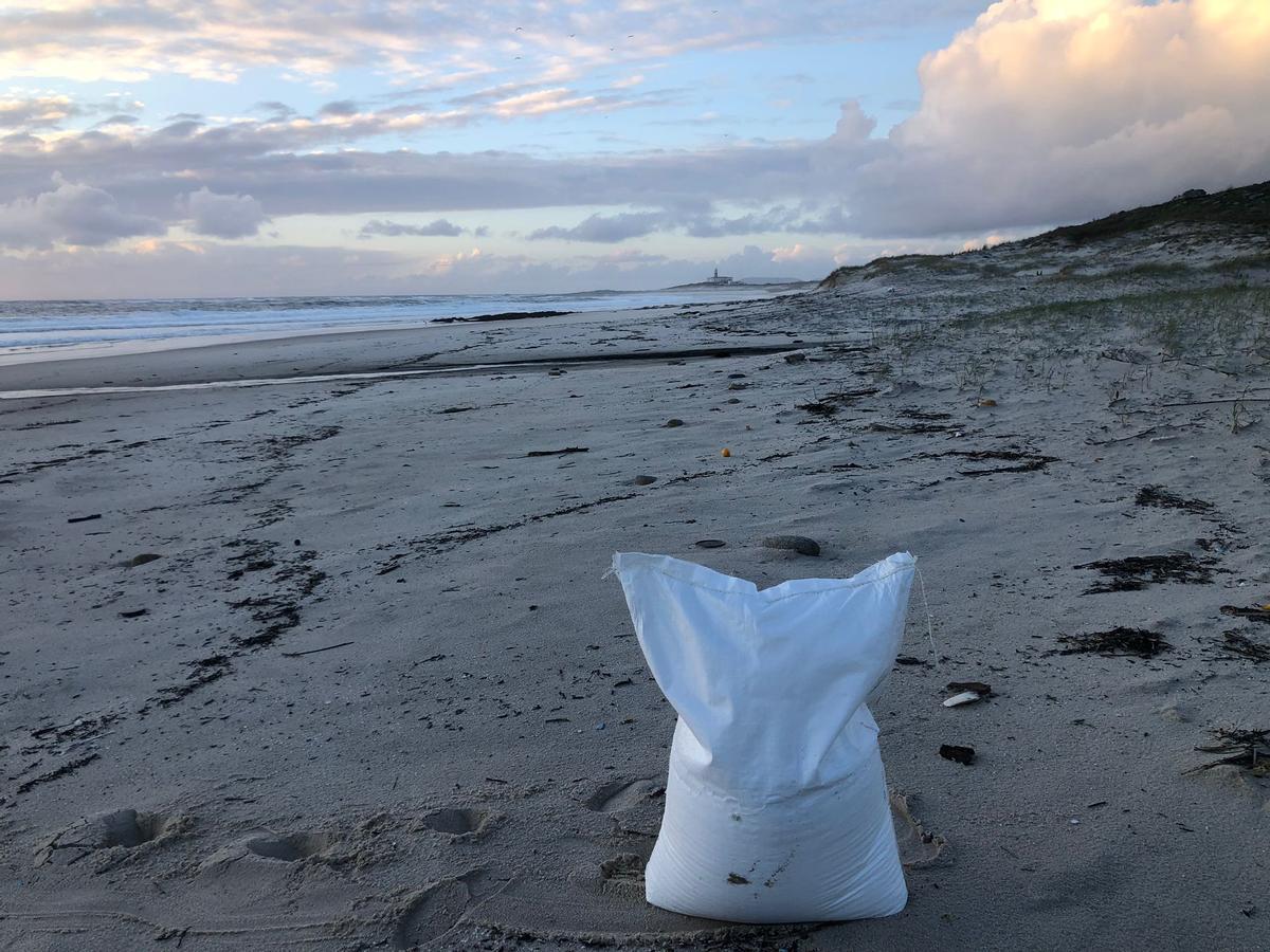 Un saco con bolas plásticas en la playa de Lariño (Carnota)