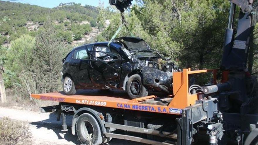 Una grúa se lleva el Peugeot 208 de color negro que cayó por un barranco.