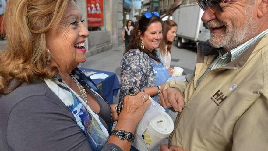 Una voluntaria recibe una aportación de un ciudadano. // G. Santos