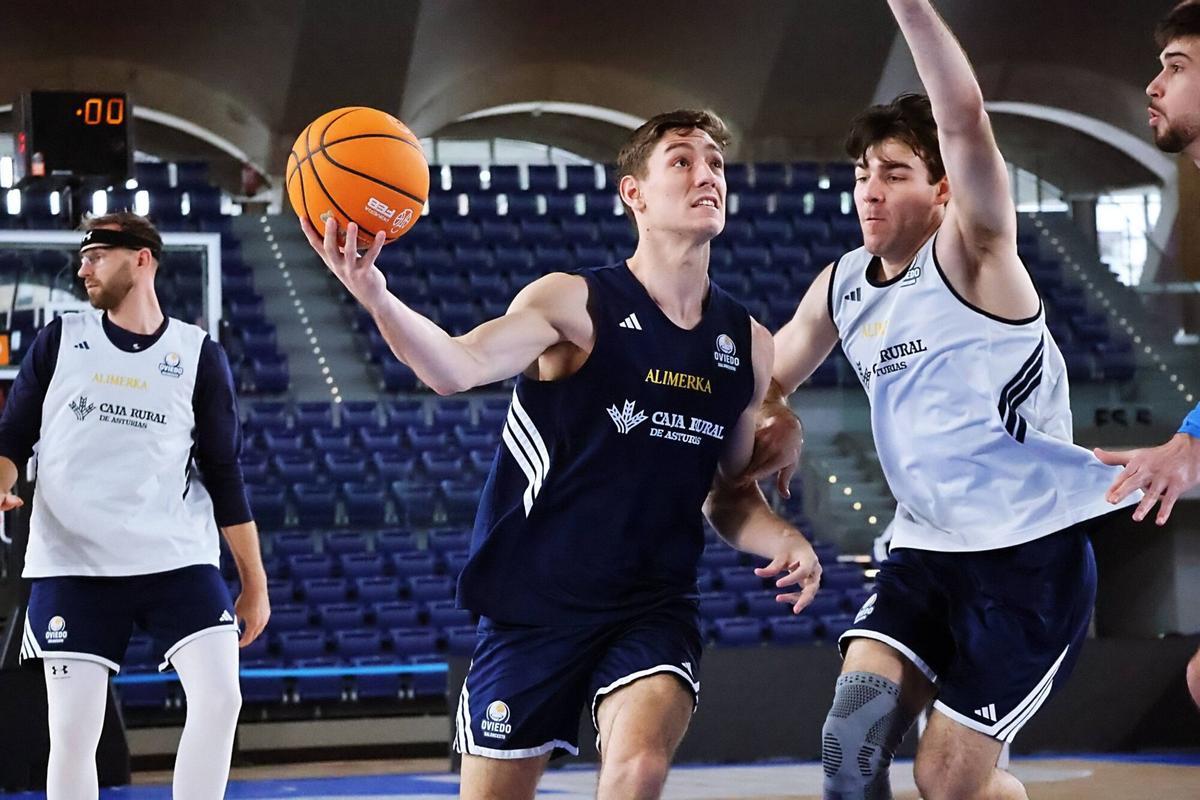Raúl Lobaco entra a canasta ante Longarela en un entrenamiento en el Palacio de los Deportes de Oviedo