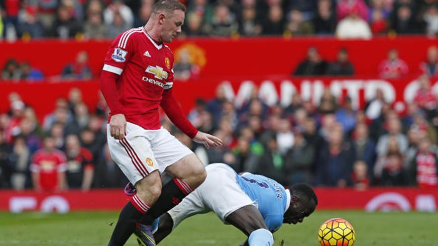 El citizen Bacary Sagna trata de interponerse ante Wayne Rooney en un momento del derbi de Manchester disputado en Old Trafford.