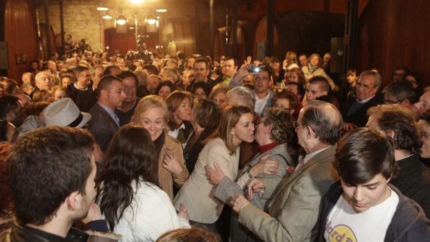 María Dolores de Cospedal besa a una militante, ayer, junto a Mercedes Fernández, en el mitin de Gijón.