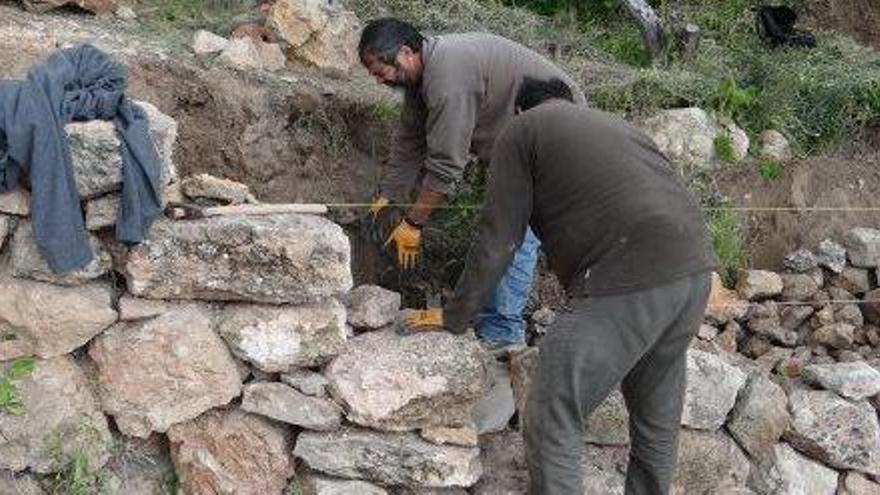 Trabajadores construyendo una pared payesa en es Cubells.