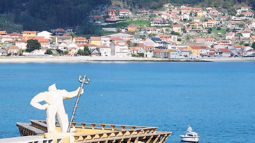 La estatua del &quot;Fisgón&quot; instalada en el paseo de Moaña y viviendas al fondo.  // Gonzalo Núñez