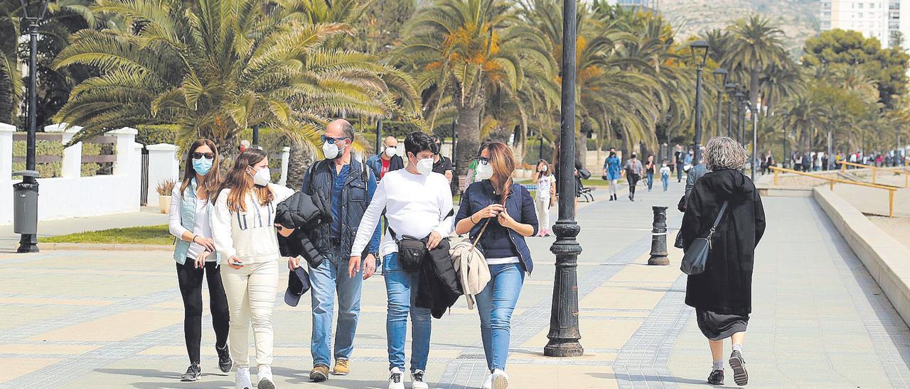 Varios ciudadanos caminan por el paseo maritímo de Benicàssim, la localidad más rica de Castellón.