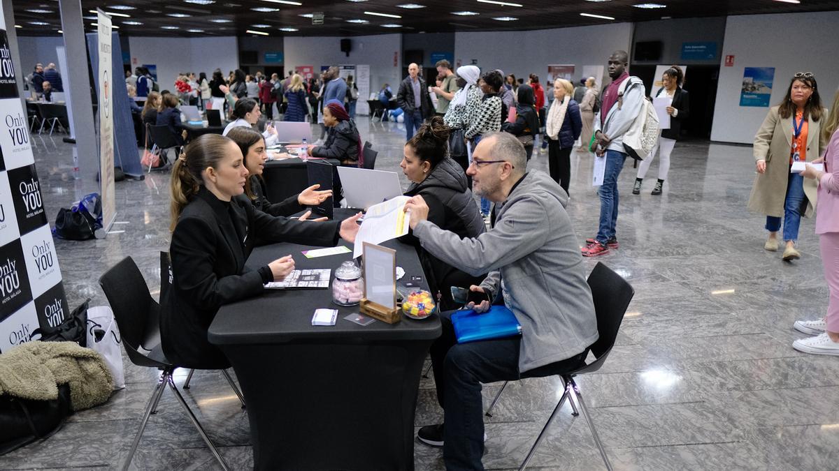 Una persona entrega el curriculum en uno de los stand de la feria que busca 1.800 trabajadores para hoteles y restaurantes en la Costa del Sol.