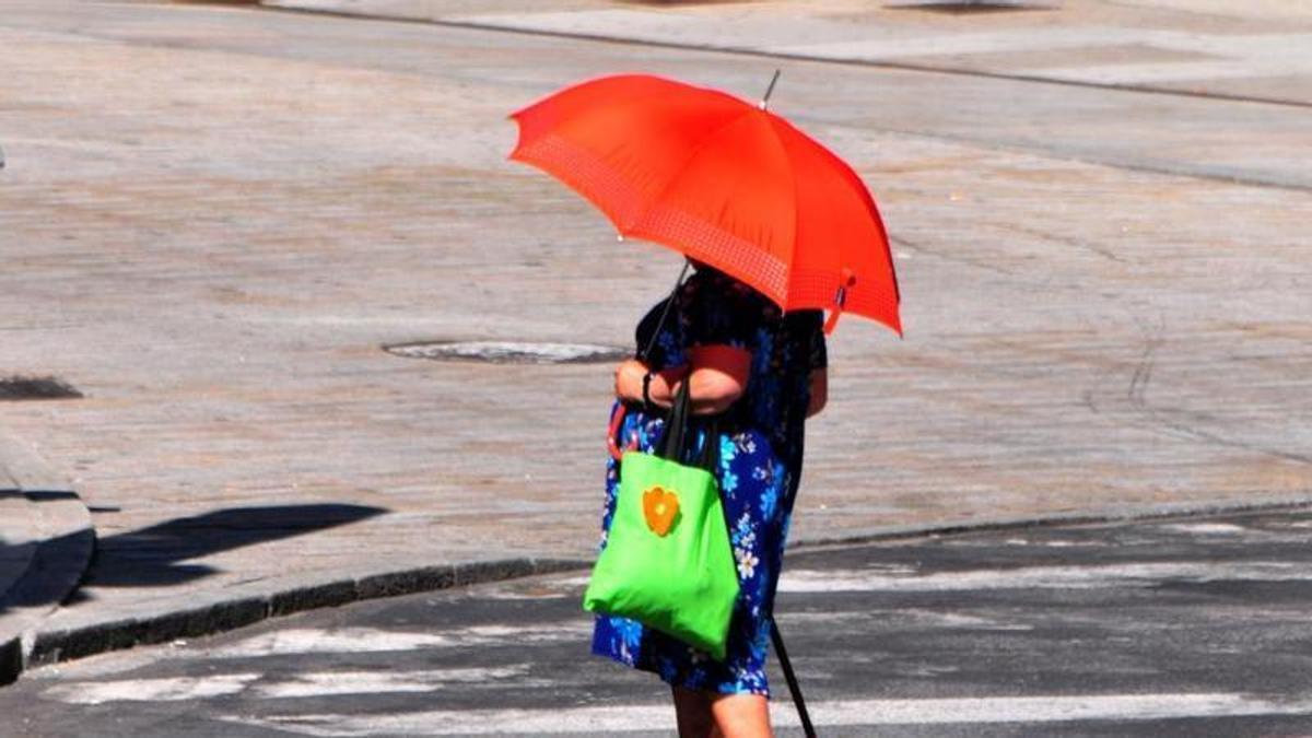 Una mujer se protege del calor con un paraguas, en Vilagarcía.