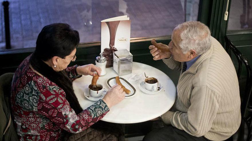 Vecinos de Valencia disfrutando de unos churros con chocolate