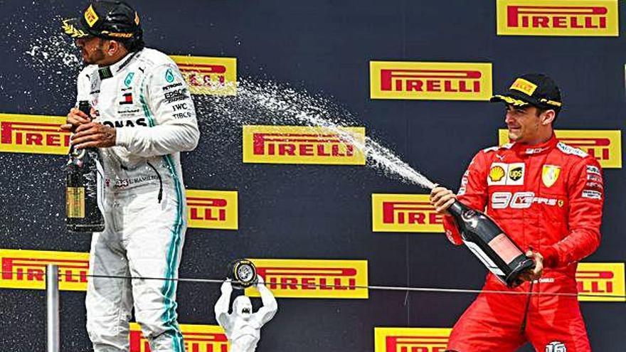 Leclerc, a la derecha, rocía con champán a Hamilton en el podio.