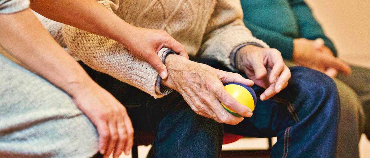 Un enfermo de Alzheimer realiza ejercicios con una pelota.