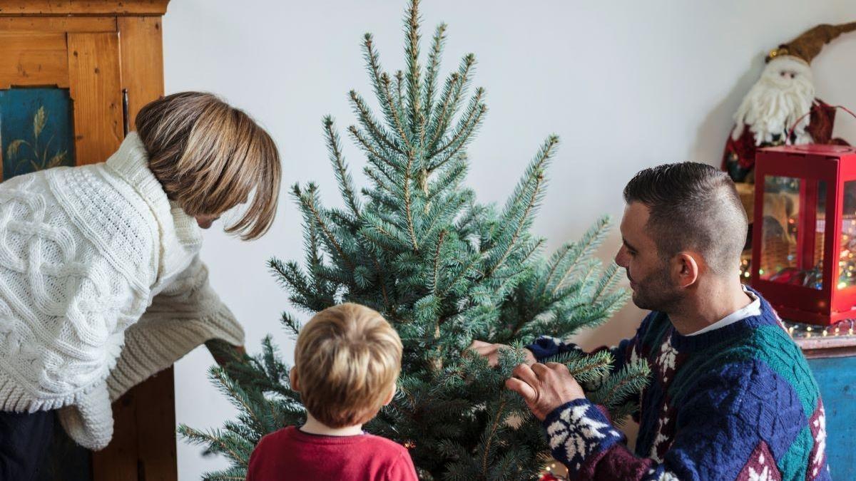 Familia decorando el árbol de Navidad en una imagen de archivo.