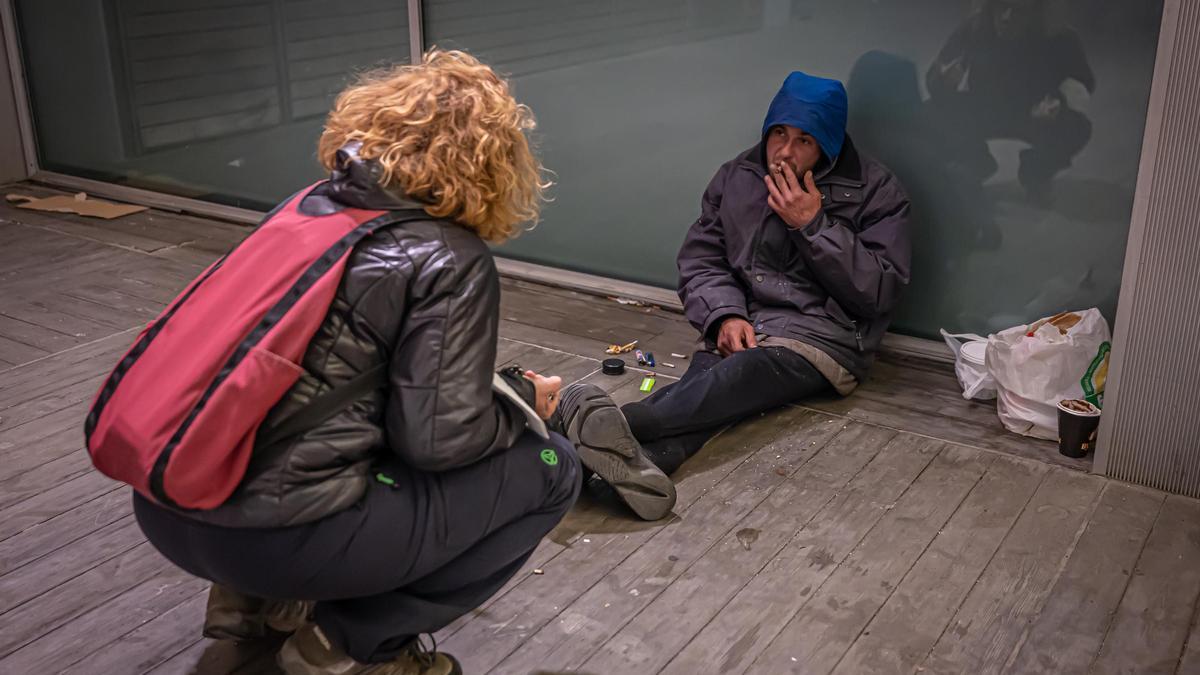 Una trabajadora social habla con un sin techo en Barcelona en enero, cuando se ofrecen lugares para dormir si el frío arrecia.