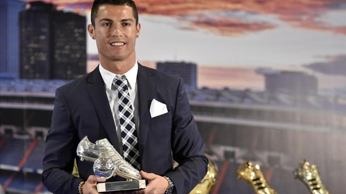 Cristiano posa con una bota de plata regalada por el club.