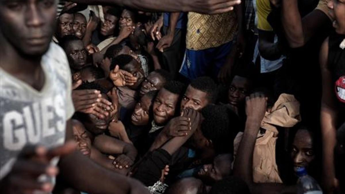 Inmigrantes africanos esperan ser recatados en alta mar cerca de Libia.