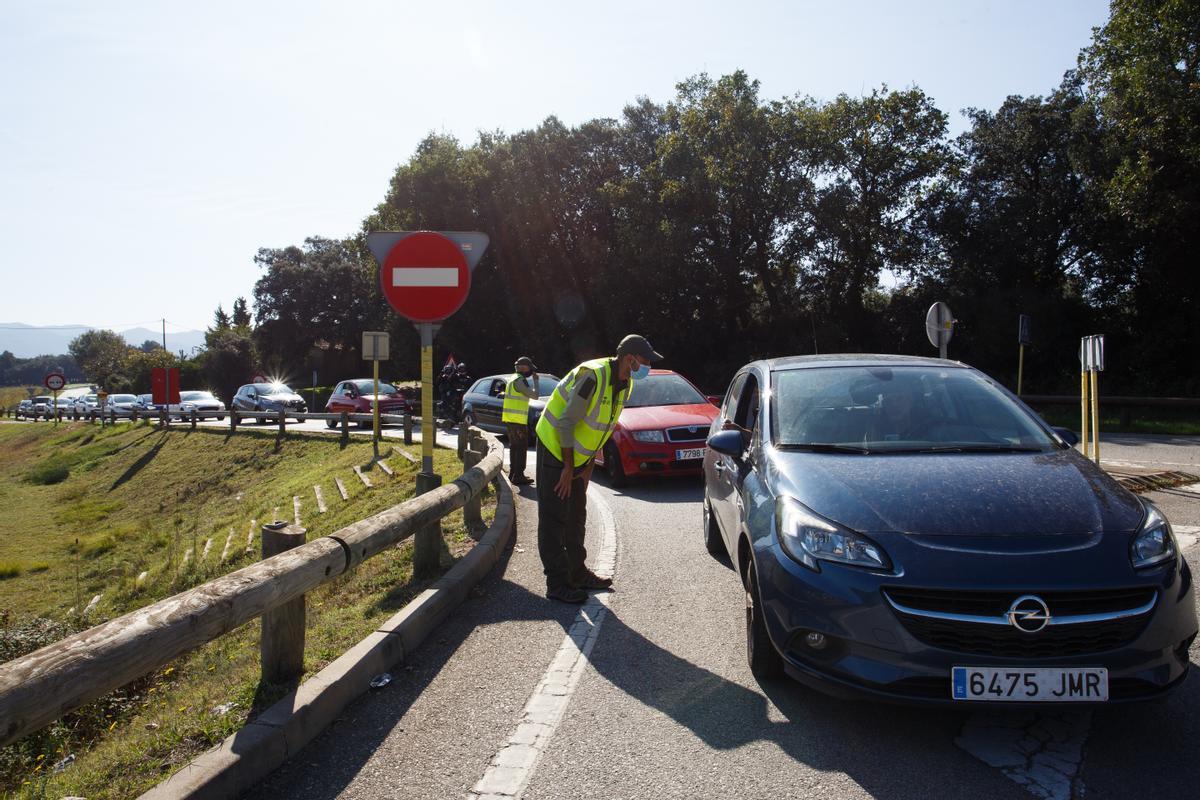 Unos informadores comunican el corte las de carreteras acceso al Parc Natural del Montseny, después de que los aparcamientos de la zona hayan quedado completos.