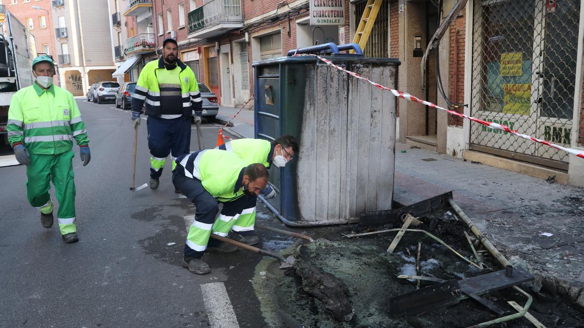 Operarios de limpieza retiran los restos que ha dejado el fuego.