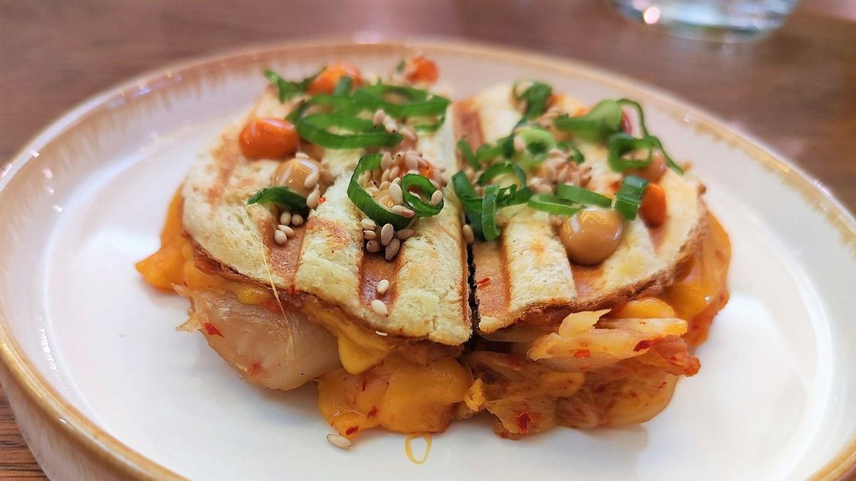Bikini raro de Last Monkey: col fermentada con una lámina de cheddar que forma parte del 'brioche' planchado de La Valenciana con puntitos de mayonesa con 'gochujang' y otra con miel.