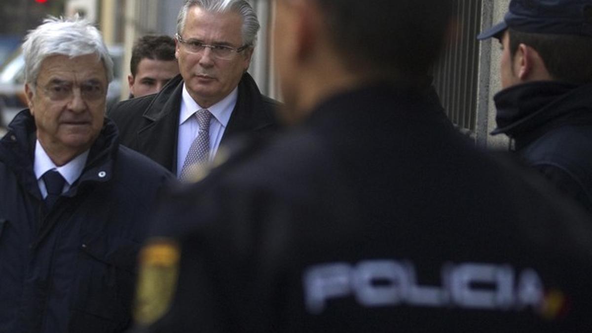 Baltasar Garzón, junto a su abogado, Francisco Baena (izquierda), llega al Tribunal Supremo, este jueves.