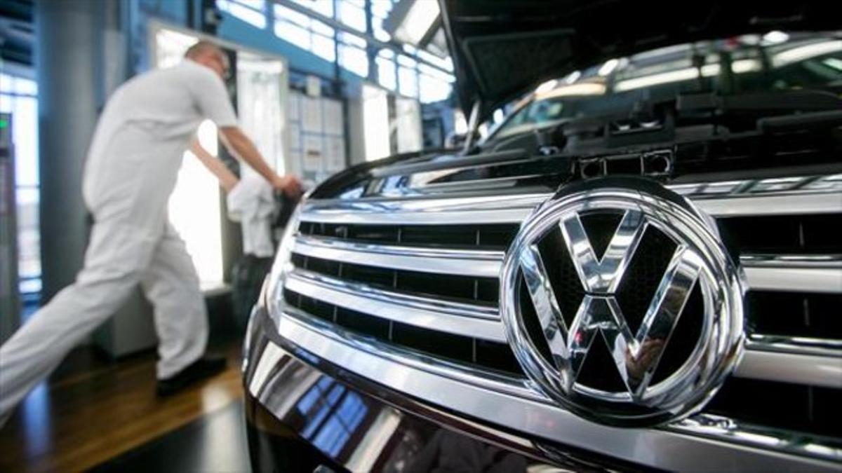 Un empleado de la Volkswagen de Dresde, junto a un Passat.