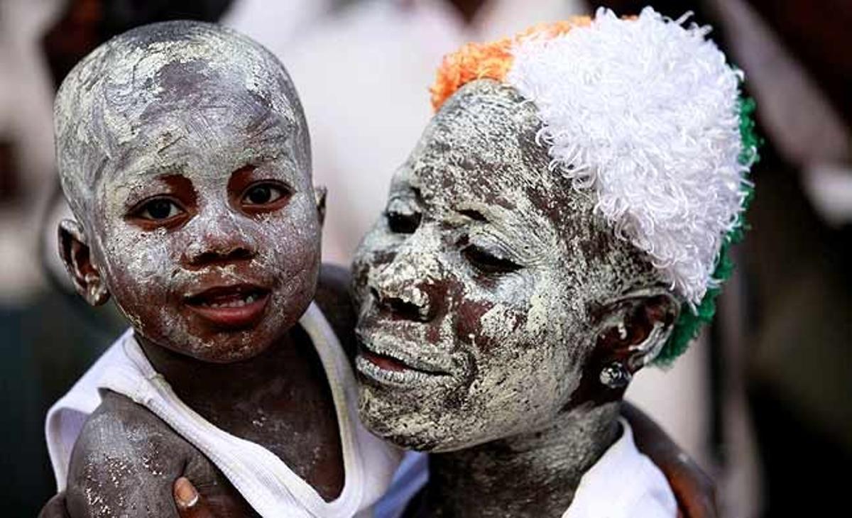 Una simpatitzant de l’actual líder de Costa d’Ivori, Laurent Gbagbo, i el seu fill porten la cara pintada amb argila durant una reunió a Abidjan (Costa d’Ivori).