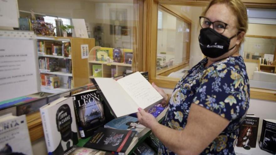 En la Biblioteca Municipal de Añaza se custodia el libro que dedicó José Saramago el día de la visita a las instalaciones que llevan su nombre. En las fotos, la bibliotecaria y el director de la red,  el alcalde y el concejal de zona. | m.pisaca/delia padrón