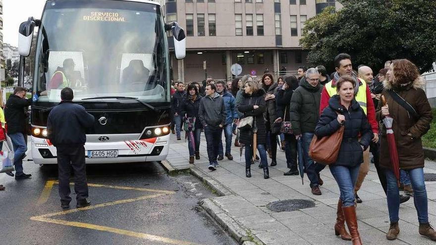 Cuatro autobuses esperaron a las puertas del juzgados a los funcionarios para ir a Santiago. // J.Lores